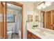 Charming bathroom with a vintage vanity, a mirror with a modern light fixture, and a framed opening looking at the bathtub at 1121 N Cambridge Ct, Greenfield, IN 46140