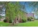 Attractive brick home with a well-maintained lawn, mature trees, and a charming garden bed along the facade at 1121 N Cambridge Ct, Greenfield, IN 46140