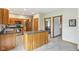 Functional kitchen includes stainless steel appliances, an island, wood cabinetry, and views into the adjacent dining room at 1121 N Cambridge Ct, Greenfield, IN 46140