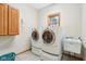 Laundry room with front loading washer and dryer, utility sink, and natural light at 1121 N Cambridge Ct, Greenfield, IN 46140