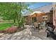 Brick patio with a grill, table, chairs, flowerbeds, and manicured lawn at 1121 N Cambridge Ct, Greenfield, IN 46140