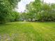 Spacious backyard with lush green grass and mature trees creating a serene outdoor space at 1141 Temperance Ave, Indianapolis, IN 46203