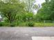 Backyard featuring green grass, mature trees, and a chain-link fence at 1141 Temperance Ave, Indianapolis, IN 46203