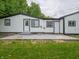Backyard patio of home with white siding, black trim, and lush green lawn at 1141 Temperance Ave, Indianapolis, IN 46203