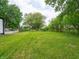 Large backyard with mature trees and lush grass, perfect for outdoor activities at 1141 Temperance Ave, Indianapolis, IN 46203