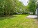 Spacious backyard featuring green grass and several shade trees near the home at 1141 Temperance Ave, Indianapolis, IN 46203