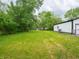 Backyard featuring green grass, mature trees, and a white house at 1141 Temperance Ave, Indianapolis, IN 46203