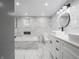 Luxurious bathroom with marble tile, double vanity, and a soaking tub at 1141 Temperance Ave, Indianapolis, IN 46203