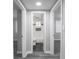Bright bathroom with tiled shower-bath, dark floor tiles and a window at 1141 Temperance Ave, Indianapolis, IN 46203
