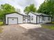 Charming white home with a well-maintained lawn and driveway leading to the garage at 1141 Temperance Ave, Indianapolis, IN 46203