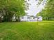 Charming home featuring a well-kept backyard with a lush green lawn and mature trees at 1141 Temperance Ave, Indianapolis, IN 46203