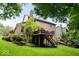 Lush backyard featuring a deck with stairs leading to the expansive lawn and garden at 11956 Glen Cove Dr, Indianapolis, IN 46236