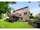 Manicured backyard showcasing home with deck, lush lawn, and thoughtfully landscaped garden beds at 11956 Glen Cove Dr, Indianapolis, IN 46236