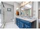 Bright bathroom with granite-topped double vanity and large mirror reflecting skylight and glass-enclosed shower at 11956 Glen Cove Dr, Indianapolis, IN 46236