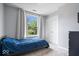 Comfortable bedroom with a plush blue bed, double door closet, and a large window overlooking green trees at 11956 Glen Cove Dr, Indianapolis, IN 46236