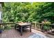 Enjoy outdoor dining on this wooden deck with a table and seating, surrounded by lush trees at 11956 Glen Cove Dr, Indianapolis, IN 46236