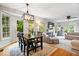 Open concept dining area with hardwood floors, stylish light fixture, and access to living room at 11956 Glen Cove Dr, Indianapolis, IN 46236