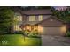 Charming two-story home with brick and siding, lush landscaping, and attached two-car garage at dusk at 11956 Glen Cove Dr, Indianapolis, IN 46236