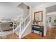 Welcoming foyer with hardwood floors, white staircase, and decorative table with mirror at 11956 Glen Cove Dr, Indianapolis, IN 46236