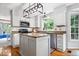 A bright kitchen features granite counters, an island, stainless appliances, and white cabinets at 11956 Glen Cove Dr, Indianapolis, IN 46236