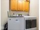 Convenient laundry area with front-loading washer and dryer and overhead cabinets for storage at 11956 Glen Cove Dr, Indianapolis, IN 46236