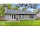 View of the back of the house showing a gray exterior, patio and grassy backyard at 12277 E Harvest Glen Dr, Indianapolis, IN 46229