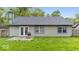 View of the back of the house showing a gray exterior and a patio extending into the grassy backyard at 12277 E Harvest Glen Dr, Indianapolis, IN 46229