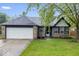 Charming single-story home with an attached two-car garage and well-manicured front lawn at 12277 E Harvest Glen Dr, Indianapolis, IN 46229