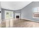 Spacious living room featuring a cozy fireplace, wood floors, and access to the backyard at 12277 E Harvest Glen Dr, Indianapolis, IN 46229