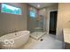 Modern bathroom boasts a soaking tub, glass-enclosed shower, and sleek fixtures at 12511 Lowery Way, Fishers, IN 46037