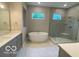 Luxurious bathroom features a freestanding tub, a glass shower and dual sinks, creating a spa-like experience at 12511 Lowery Way, Fishers, IN 46037