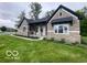 Inviting single-story home with beautiful stone facade, covered entryway, and lush green lawn at 12511 Lowery Way, Fishers, IN 46037