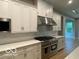 Modern kitchen boasts white cabinets, subway tile backsplash, professional-grade gas range, and stainless hood at 12511 Lowery Way, Fishers, IN 46037