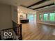 Open-concept living space with hardwood floors, modern kitchen, and exposed beams for a contemporary feel at 12511 Lowery Way, Fishers, IN 46037