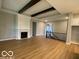 Open-concept living room featuring hardwood floors, a fireplace, and exposed ceiling beams at 12511 Lowery Way, Fishers, IN 46037