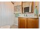 Bathroom with wood cabinets, a mirror, and decorative wallpaper at 126 N Darlington St, Jamestown, IN 46147