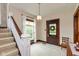 Bright foyer with staircase, featuring a wooden front door and light-filled windows at 126 N Darlington St, Jamestown, IN 46147