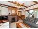 Comfortable living room with a brick fireplace, wood paneling, ceiling fan, and cozy furnishings at 126 N Darlington St, Jamestown, IN 46147