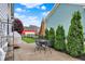 A patio with a table, grill covered, and a view of the lush backyard at 12999 Deerstyne Green St, Carmel, IN 46032