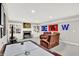 Cozy basement features a fireplace, built-in shelving, plush seating, and an air hockey table for entertainment at 12999 Deerstyne Green St, Carmel, IN 46032