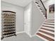 A well-organized basement features a wine rack, staircase, and doorway, perfect for storage or entertaining at 12999 Deerstyne Green St, Carmel, IN 46032