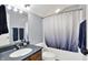 Bathroom featuring a single sink vanity, dark countertop, and a shower with a white and blue gradient curtain at 12999 Deerstyne Green St, Carmel, IN 46032
