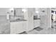 This bright bathroom features marble tile, white cabinets, and double sinks at 12999 Deerstyne Green St, Carmel, IN 46032