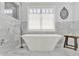Freestanding tub with marble tile and fixtures in modern bathroom at 12999 Deerstyne Green St, Carmel, IN 46032