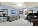 Office or bedroom with gray sofa, blue walls, neutral carpet, a fan, and a window at 12999 Deerstyne Green St, Carmel, IN 46032