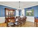 Traditional dining room boasts blue walls, wood floors, chandelier, and a beautiful china cabinet at 12999 Deerstyne Green St, Carmel, IN 46032