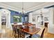 Elegant dining room with wood floors, blue accent wall, and a chandelier over a large wooden table at 12999 Deerstyne Green St, Carmel, IN 46032