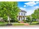 Two-story white brick home featuring a welcoming front porch and mature landscaping at 12999 Deerstyne Green St, Carmel, IN 46032