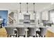 Bright kitchen showcases a large island with seating, granite counters, stainless appliances, and hardwood flooring at 12999 Deerstyne Green St, Carmel, IN 46032