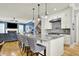Open kitchen featuring a large island with seating, granite countertops, stainless appliances, and pendant lighting at 12999 Deerstyne Green St, Carmel, IN 46032